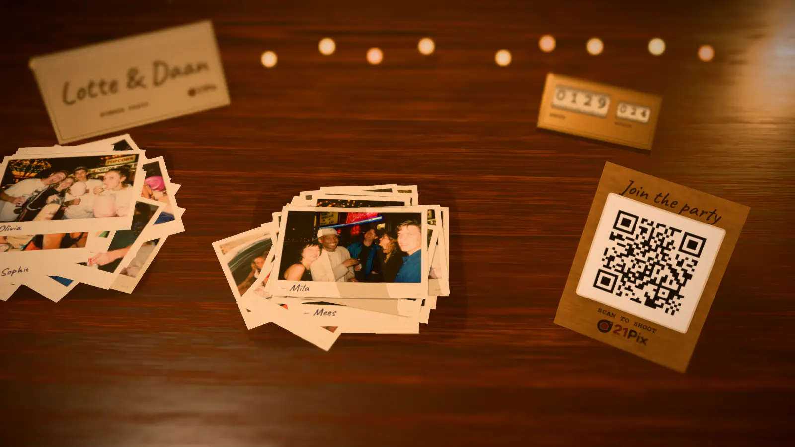 The 21Pix big screen: guests' photos as prints on a wooden table, with names handwritten on them
